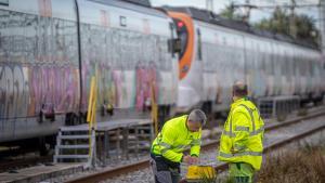 Personal del administrador de infraestructuras, Adif, trabajan junto al trazado de la línea R1 de Rodalies del Maresme.