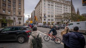 Peatones esperan que un coche y una bici pasen para poder cruzar. En realidad deberían pasar ellos y el coche y la bici, esperar.