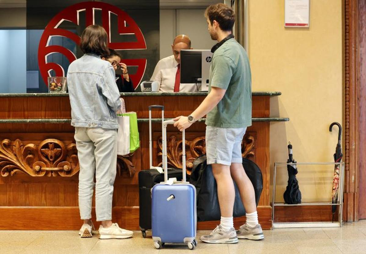 Clientes se registran a su llegada a la recepción de un hotel.