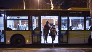 Dos mujeres bajan de un bus nocturno del AMB