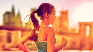 Running woman Asian runner in New York city sunset. Runner jogging in sunny bright light. Female fitness model training outside in New York City with skyline and Brooklyn Bridge in background.