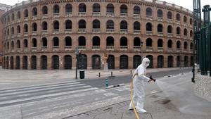 GRAFCVA3193. VALENCIA, 19/03/2020.- Un miembro de la Unidad Militar de Emergencias (UME), realizan trabajos de desinfección ante la Plaza de Toros de Valencia duante la quinta jornada en estado de alarma por el coronavirus. EFE/Juan Carlos Cárdenas