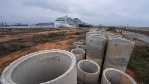 Varios tubos para canalizaciones de obras en el Moll Adossat del Port de Barcelona, con un crucero de MSC atracado.